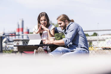 Young couple using tablet in a beer garden - UUF18448