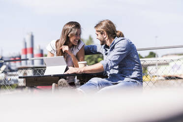 Happy young couple with tablet in a beer garden - UUF18449