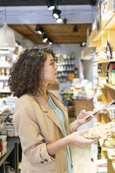 Junge Frau beim Einkaufen in einem Lebensmittelgeschäft - AFVF03606