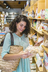 Junge Frau beim Einkaufen in einem Lebensmittelgeschäft - AFVF03620