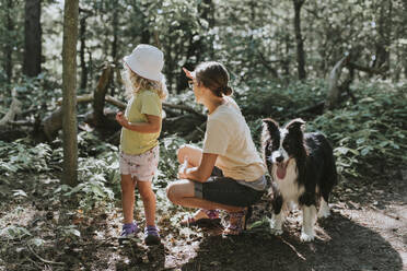 Mutter mit Tochter und Hund in einem Wald - DWF00459
