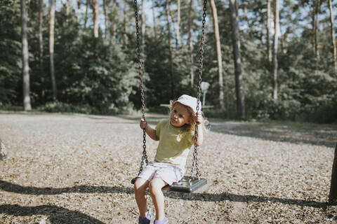 Mädchen auf der Schaukel auf einem Spielplatz, lizenzfreies Stockfoto