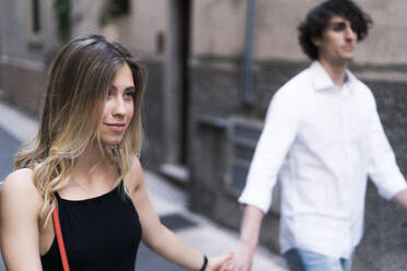 Junges Paar geht Hand in Hand in der Stadt spazieren - GIOF07008