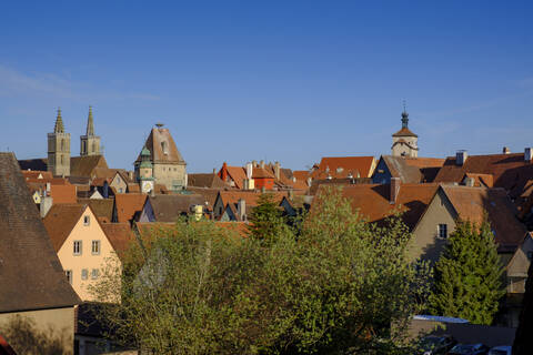 Blick von oben auf Häuser und Rathausturm in Rothenburg vor blauem Himmel, Bayern, Deutschland, lizenzfreies Stockfoto