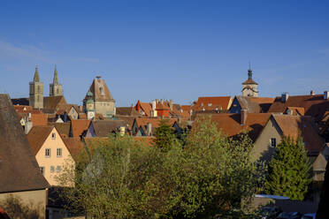 Blick von oben auf Häuser und Rathausturm in Rothenburg vor blauem Himmel, Bayern, Deutschland - LBF02668