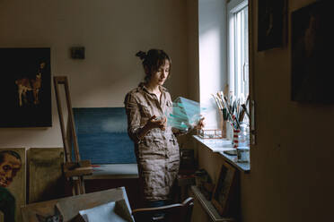 Künstlerin hält Glasscheibe in ihrem Atelier - OGF00097