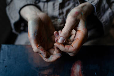 Close-up of painted hands of a female painter in her studio - OGF00103