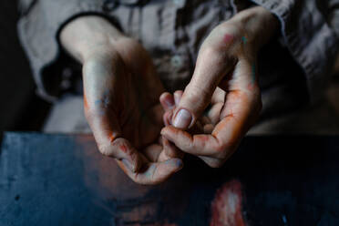 Nahaufnahme der bemalten Hände einer Malerin in ihrem Atelier - OGF00103