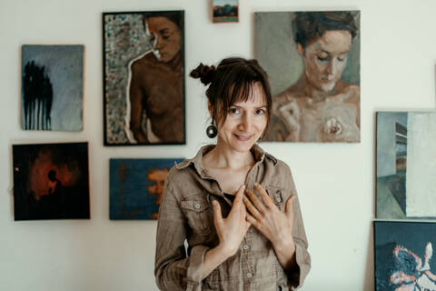 Porträt einer lächelnden Malerin in ihrem Atelier, lizenzfreies Stockfoto