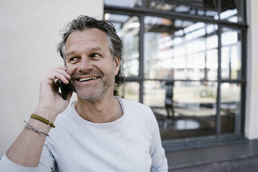Smiling mature man using smartphone - KNSF06120