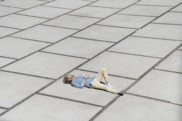 Young man lying on a square - KNSF06181
