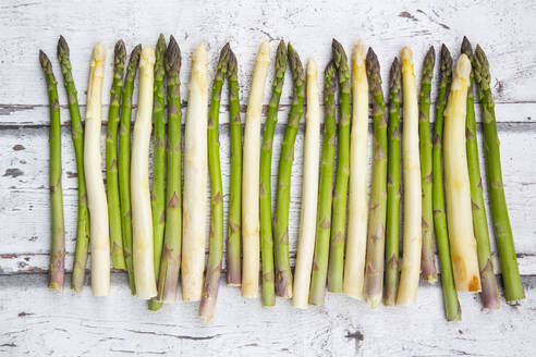 High angel view of white and green asparagus on wooden table - LVF08234