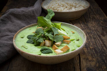 Close-up of green curry and jasmine rice in bowls on table - LVF08237