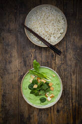 Directly above shot of green curry and jasmine rice in bowls on table - LVF08238