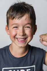 Portrait of strong boy, laughing, white background - MGIF00655