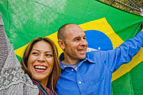 Hispanisches Paar hält brasilianische Flagge - BLEF13465