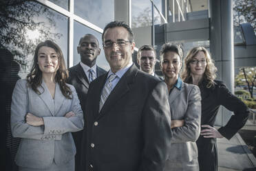 Business people smiling outside office building - BLEF13525