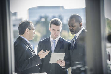 Geschäftsleute benutzen ein digitales Tablet außerhalb des Büros - BLEF13529