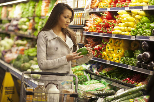 Gemischtrassige Frau kauft Produkte im Supermarkt - BLEF13662