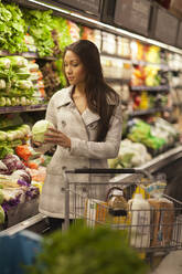 Gemischtrassige Frau kauft Produkte im Supermarkt - BLEF13663