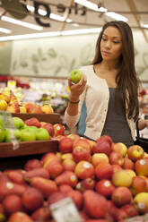 Gemischtrassige Frau kauft Produkte im Supermarkt - BLEF13665