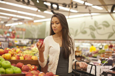 Gemischtrassige Frau kauft Produkte im Supermarkt - BLEF13666