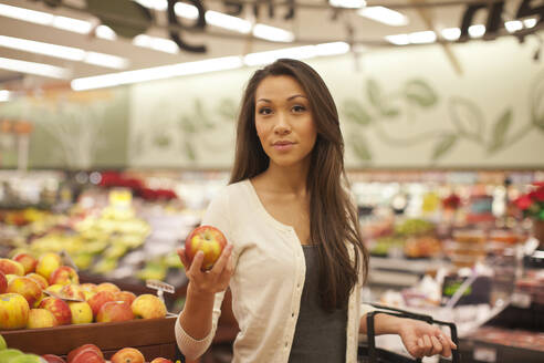 Gemischtrassige Frau kauft Produkte im Supermarkt - BLEF13667