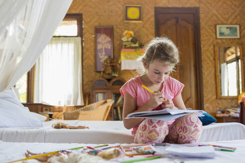 Caucasian girl coloring in bedroom - BLEF13726