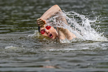 Junger Triathlet beim Schwimmen in einem See - STSF02166