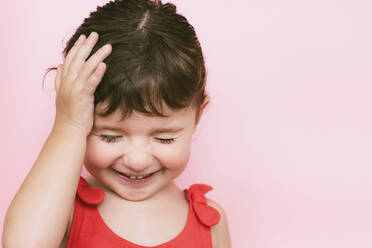 Portrait of giggling little girl in front of pink background - GEMF03040