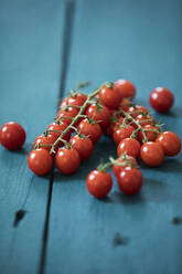 Strauß Tomaten auf blauem Holz - MAEF12902