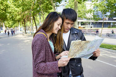 Touristenpaar mit Blick auf die Landkarte, Barcelona, Spanien - GEMF03043