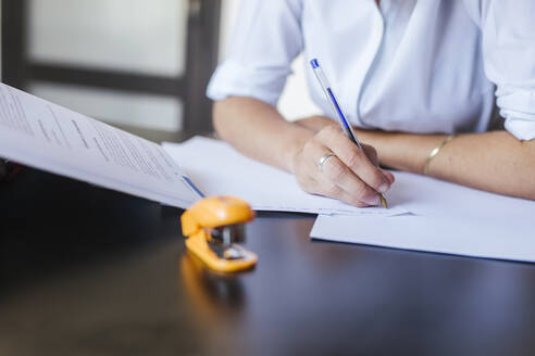 Close-up of female student learning at desk at home taking notes - LJF00591