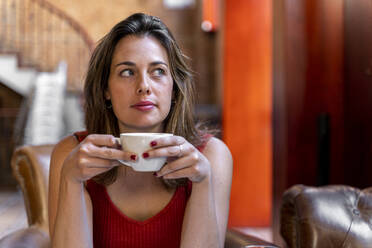 Portrait of young woman with cup of coffee - AFVF03645