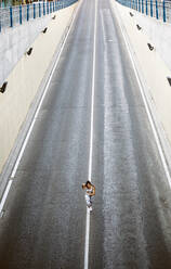 Top view of sporty young woman running on a street - OCMF00552