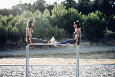 Two twin sisters exercsing on parallel bars - OCMF00555