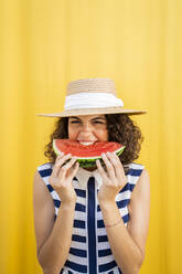 Porträt einer Frau, die eine Wassermelone isst, gelber Hintergrund - AFVF03667