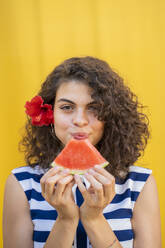 Porträt einer Frau, die eine Wassermelone isst, gelber Hintergrund - AFVF03668