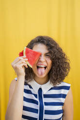 Portrait of young woman with water melon, sticking out her tongue - AFVF03669