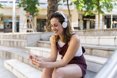 Junge Frau benutzt Smartphone und hört Musik - AFVF03683