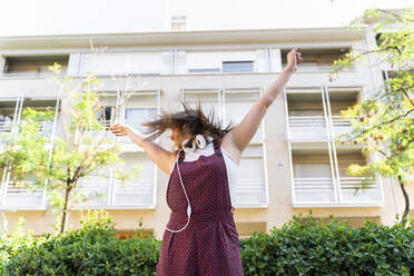 Young woman listening music, raised arms - AFVF03697