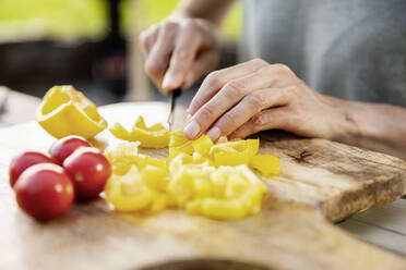 Nahaufnahme einer Frau, die im Freien gesundes Essen zubereitet - FMKF05784