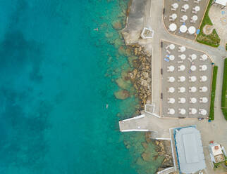 Luftaufnahme einer Strandanlage mit weißen Sonnenschirmen, Insel Rhodos, Griechenland. - AAEF00163