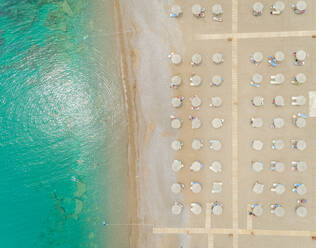 Luftaufnahme des mit Strohsonnenschirmen gesäumten Strandes, Insel Rhodos, Griechenland. - AAEF00183