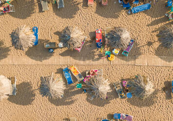 Aerial view of wooden walkway through straw parasols on beach in Achaia, Greece. - AAEF00209