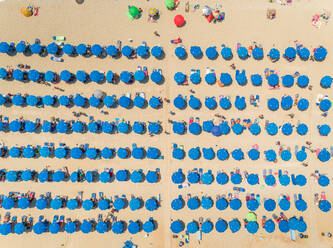 Aerial view of crowded beach with blue parasols on Lefkada, Greece. - AAEF00237