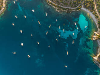 Aerial view of group of boats anchored in the mediterranean sea, Kastos island, Greece. - AAEF00245