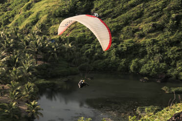 Luftaufnahme von zwei Männern beim Gleitschirmfliegen über dem Arambol-Strand in Nord-Goa, Indien. - AAEF00311