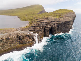 Luftaufnahme eines Wasserfalls in der Nähe der englischen Sklavenklippe im Nordatlantik, Färöer-Insel. - AAEF00368