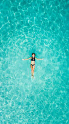 Aerial view of a woman floating in the sea of Ithaca island. - AAEF00420